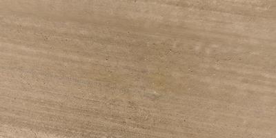 vue de dessus de la surface de la route de gravier faite de petites pierres et de sable avec des traces de pneus de voiture photo