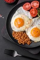 délicieux copieux petit déjeuner qui consiste de deux frit œufs, en conserve Lentilles et microgreens photo