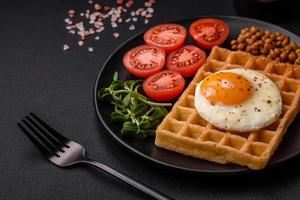 délicieux copieux petit déjeuner qui consiste de une frit œuf, Belge gaufre photo