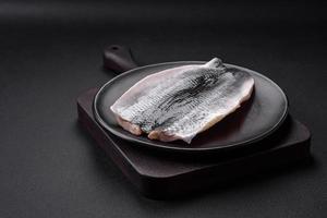 délicieux salé hareng filet dans pétrole sur une noir céramique assiette