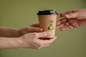 recyclé emballage concept. fermer de barista donnant une chaud tasse de café à client. zéro déchets matériaux. environnement se soucier, réutilisation, renouvelable pour durable mode de vie photo