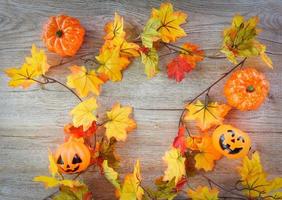 Halloween Contexte avec sec feuilles l'automne sur en bois décoré vacances de fête concept - jack o lanterne citrouille Halloween décorations pour fête accessoires objet , Haut vue plat allonger photo