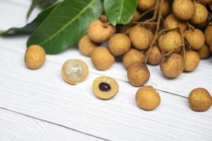 longan Frais tropical fruit et vert feuille dans Thaïlande - dimocarpus longan et peler exotique des fruits sur blanc en bois Contexte photo