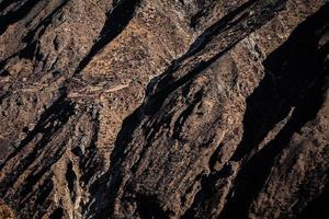 le texturé côté de une Montagne avec maison construire sur il photo