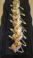 Saumon oyako épicé rouleau consister de croustillant Saumon peau est enveloppé avec Sushi riz, surmonté avec moitié grillé aburi Saumon avec épicé sauce photo