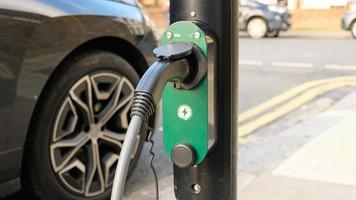 électrique véhicule mise en charge à une Publique mise en charge station dans une ville paramètre. Nouveau énergie Véhicules, respectueux de la nature alternative énergie pour voitures. électrique voitures sont devenir plus commun et gagner popularité. photo