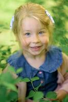 une peu fille 3 ans vieux des promenades dans le parc dans une robe et une rose chandail. photo