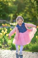 une peu fille 3 ans vieux des promenades dans le parc dans une robe et une rose chandail. photo