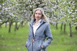 une belle femme âgée posant dans un jardin fleuri au printemps. photo