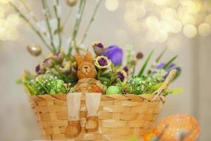 Pâques panier avec décoratif œufs, fleurs et une lapin miniature. photo