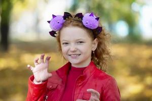 une fille dans décontractée vêtements et avec une Bandeau avec Halloween cornes fait peur toi. Halloween concept. photo