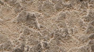 mer mousse avec sable. surface de clair l'eau sur tropical sablonneux océan côté dans Crète Grèce. grincer structure particulier projecteur sur le des pierres, obscurci fondation.paysage marin de mer rive dans été les mers photo