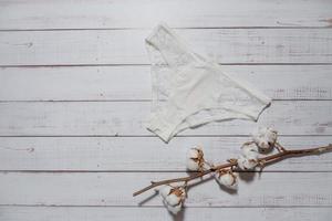 blanc dentelle caleçon avec coton brunch sur en bois arrière-plan, fermer photo