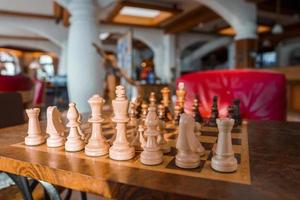en bois blanc et marron échecs pièces arrangé sur échiquier dans Hôtel photo
