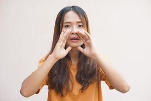 asiatique femme chuchotement avec sa main couvrant sa voix photo