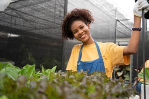 portrait de content moitié thaïlandais moitié africain femme agriculteur permanent derrière légume terrain dans sa cour. concept de agriculture biologique pour santé, végétalien nourriture et petit entreprise. photo