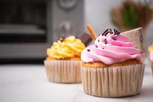 délicieux cupcakes faits maison avec crème colorée et garniture de bonbons et biscuits au chocolat. dessert de vacances d'automne fait maison photo