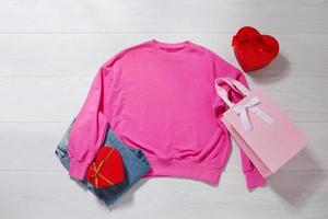 rose sweat-shirt maquette. valentines journée concept chemise, cadeau boîte cœur forme sur en bois Contexte. copie espace, modèle Vide de face vue vêtements. romantique tenue. plat allonger anniversaire vacances mode photo