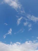 beaux nuages blancs sur fond de ciel bleu profond. de grands nuages doux et moelleux couvrent tout le ciel bleu. photo