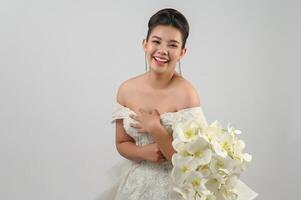 Jeune belle mariée asiatique souriante avec plaisir sur fond blanc photo