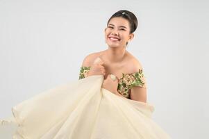 Jeune belle mariée asiatique souriante avec plaisir sur fond blanc photo