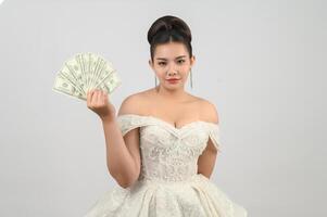 jeune belle mariée asiatique tenant des billets d'un dollar à la main photo