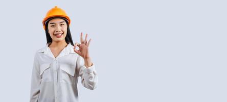 Jeune femelle ingénieur portant Jaune casque et main signe posture photo