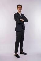 portrait de jeune homme d'affaires beau portant un costume debout avec les bras croisés avec isolé sur fond blanc de studio photo