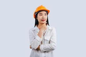 Jeune femelle ingénieur dans casque supporter avec réfléchi posture photo
