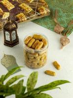 castengel biscuits dans une pot sur blanc tableau. castengel ou kaasstengels est néerlandais influencé indonésien fromage biscuits. il d'habitude servi dans Ramadan, eid fitr et eid adha. photo