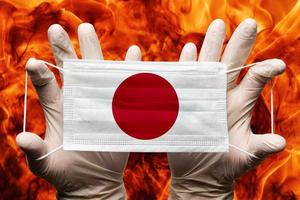 médecin en portant dans blanc gants protection médical visage masque, respiratoire bandage avec Japon nationale pays drapeau superposé sur masque. concept photo