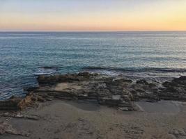 Plage méditerranéenne sans personnes au coucher du soleil à calpe, alicante photo