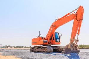 Excavatrice sur un chantier de construction sur fond de ciel bleu photo