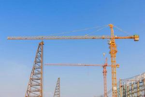 Grues de construction industrielle et bâtiment dans un beau fond de ciel bleu photo