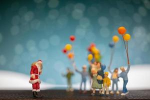 Père Noël miniature et enfants tenant des ballons, joyeux Noël et bonne année concept photo