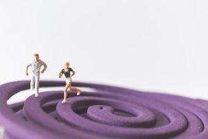 Couple miniature fonctionnant sur un champ circulaire violet photo