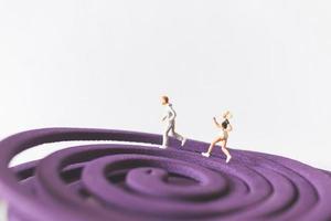 Couple miniature fonctionnant sur un champ circulaire violet photo