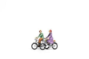 Couple miniature à bicyclette sur fond blanc, concept de la Saint-Valentin