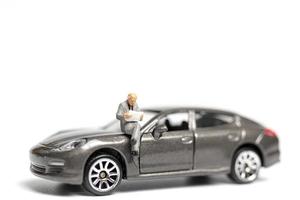 personnes miniatures assis sur une voiture sur fond blanc photo