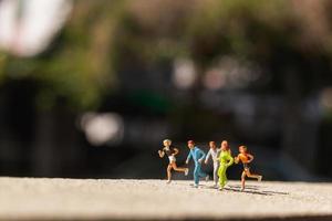 Groupe miniature de personnes qui courent sur une route en béton, concept de mode de vie sain photo