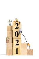 personnes miniatures grimpant sur des cubes en bois avec le numéro 2021, concept de bonne année photo