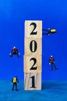 plongeurs miniatures plongeant autour de blocs de bois avec le numéro 2021, concept de bonne année photo
