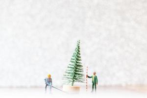 Travailleurs miniatures préparant un arbre de Noël, concept de décoration de Noël photo