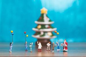 Famille miniature célébrant Noël sur fond bleu photo