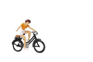 Voyageur miniature avec un vélo isolé sur fond blanc photo