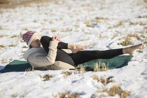 Une jeune femme athlétique effectue des exercices de yoga et de méditation à l'extérieur photo