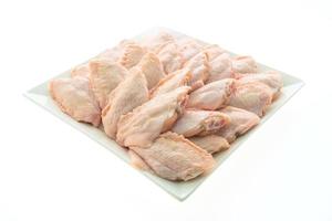 Ailes de poulet cru sur plaque blanche photo