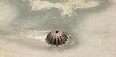 vieux rustique l'eau drainer avec métal le fer Matériel sur toit Haut isolé sur béton sol. photo