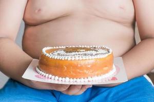 gâteau dans obèse main garçon photo
