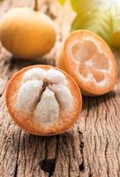 tranché santol fruit sur bois Contexte photo